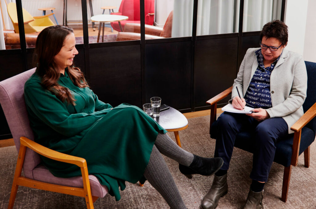 Zwei Beraterinnen von relations Hamburg sitzen auf Sesseln und sprechen über Mediation