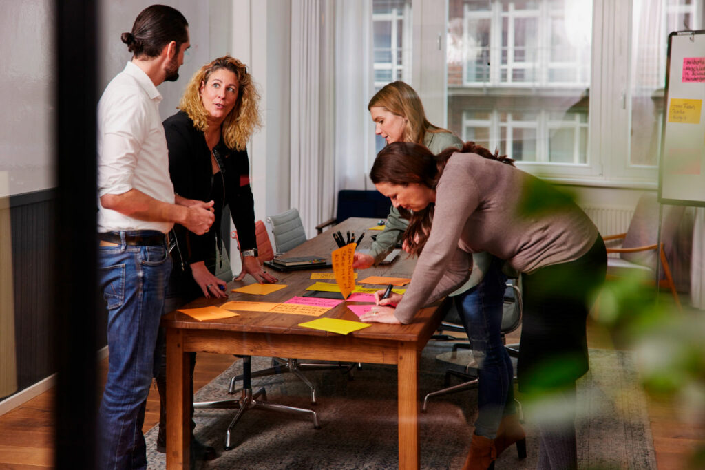 relations Hamburg Beraterinnen arbeiten zusammen an einem Holztisch