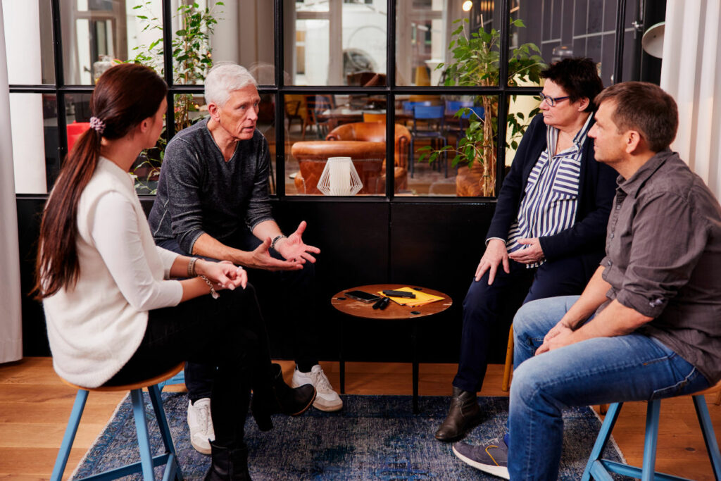 relations Hamburg Mitarbeiter sitzen im Kreis und diskutieren über Mediation