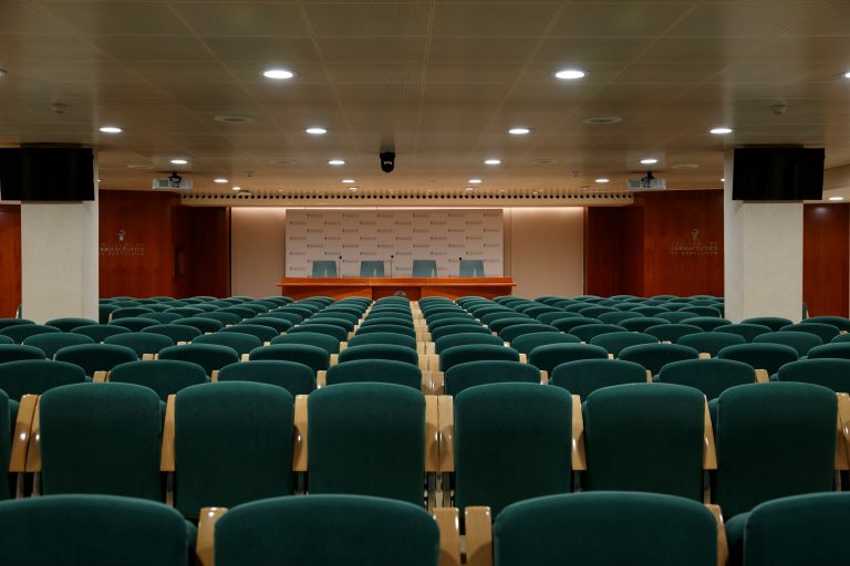Konferenzsaal mit grünen Stuhlreihen